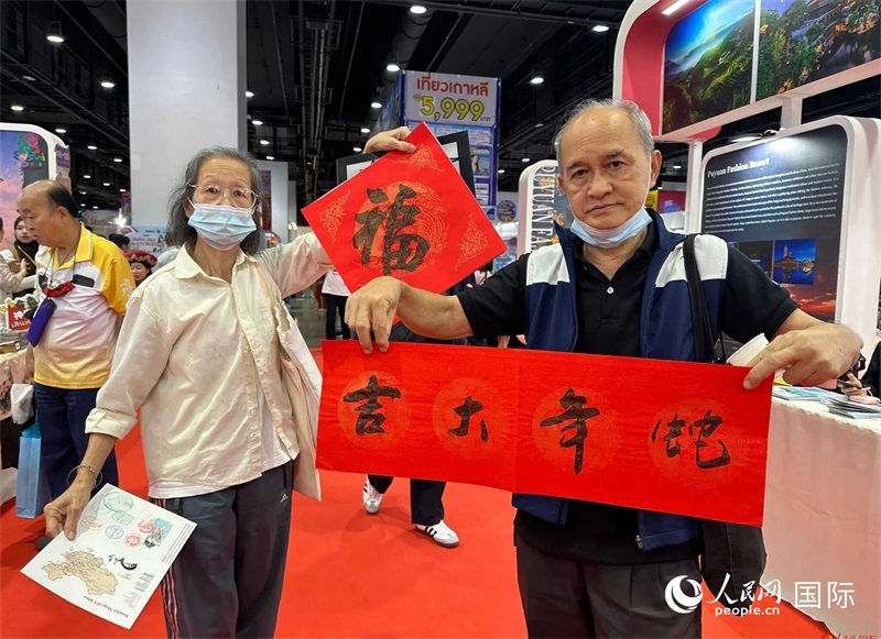 2025蛇年春節(jié)，泰國市民展示他們領(lǐng)到的華人手寫春聯(lián)。人民網(wǎng)記者 簡承淵攝