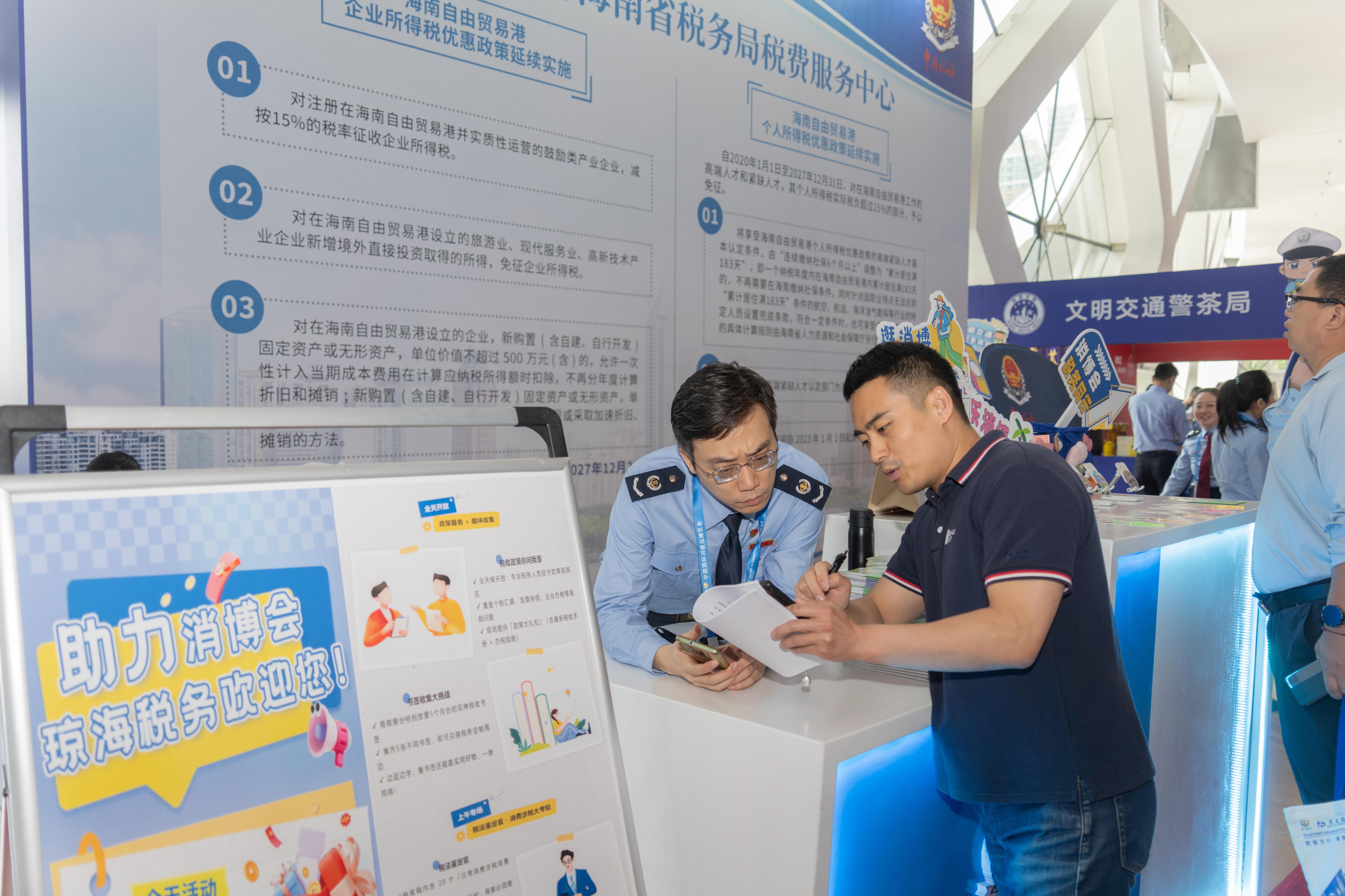 稅務(wù)服務(wù)臺(tái)工作人員向記者介紹服務(wù)參展外商的具體舉措。人民網(wǎng)記者 許崢攝