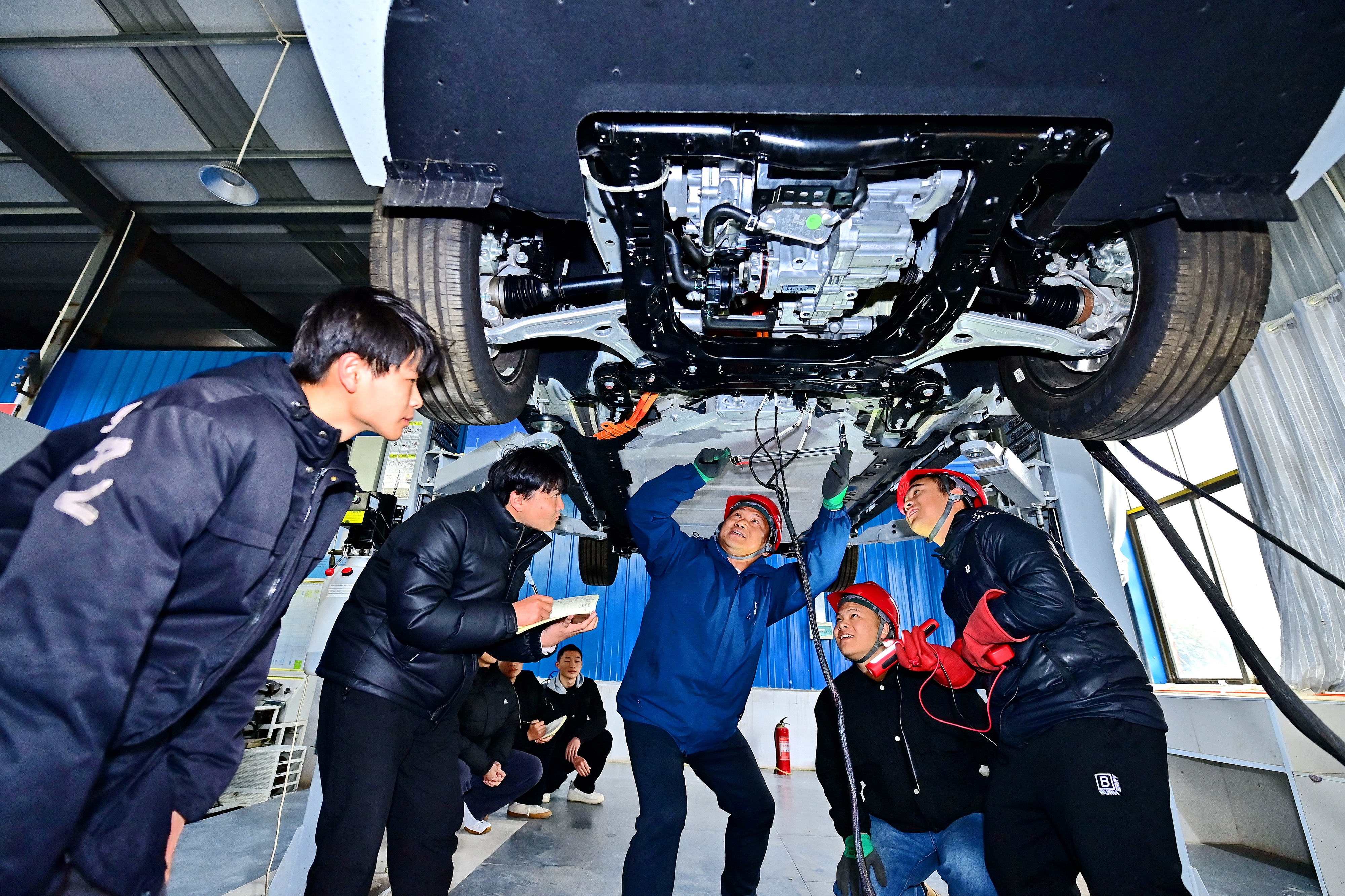 2025年2月，江西省宜春市，豐城市的一所技工學(xué)校實(shí)訓(xùn)基地內(nèi)，新能源汽車運(yùn)維專業(yè)學(xué)生在老師的指導(dǎo)下學(xué)習(xí)新能源汽車電池包檢修技術(shù)。