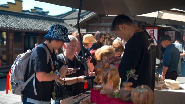 “五一”期間，游客正在烏鎮(zhèn)“水鄉(xiāng)碼頭”挑選購(gòu)買(mǎi)文創(chuàng)產(chǎn)品。受訪者供圖