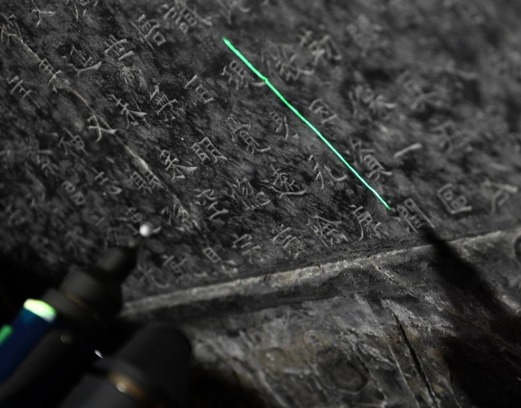 2025年4月9日，龍門(mén)石窟研究院工作人員在古陽(yáng)洞使用關(guān)節(jié)臂掃描儀對(duì)《龍門(mén)二十品》之一進(jìn)行數(shù)字化掃描。新華社記者 李嘉南 攝