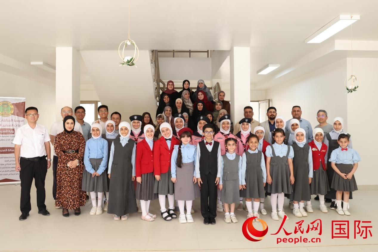 中國電建員工與阿爾穆塔?阿里卡特國際學校的師生及政府官員等合影。人民網記者 薛丹攝