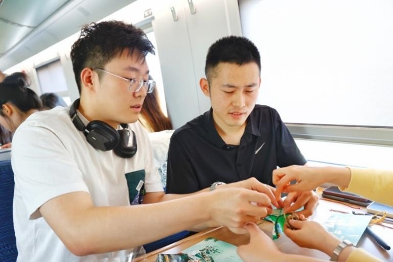 G232次旅客親手制作端午荷包和五彩繩。王磊攝