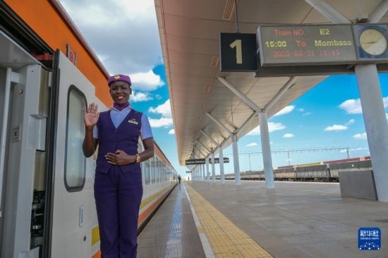 5月31日，在蒙內(nèi)鐵路內(nèi)羅畢站，一名乘務(wù)員在即將開(kāi)往蒙巴薩的E2次列車(chē)旁等候乘客。新華社記者 楊光 攝