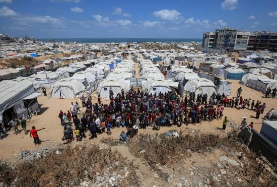 5月28日，人們在加沙城西部的沙提難民營等待領(lǐng)取救助食物。新華社發(fā)（里澤克·阿卜杜勒賈瓦德攝）