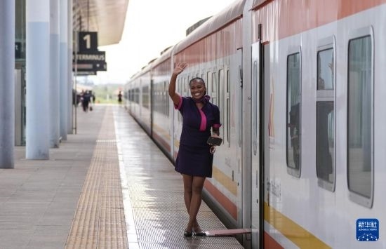 5月31日，在蒙內(nèi)鐵路內(nèi)羅畢站，一名乘務(wù)員在即將開(kāi)往蒙巴薩的E2次列車(chē)旁等候乘客。新華社記者 李亞輝 攝