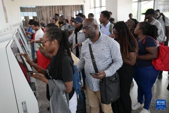 5月31日，在蒙內(nèi)鐵路內(nèi)羅畢站，乘客在自助取票機(jī)前排隊(duì)取票。新華社記者 楊光 攝