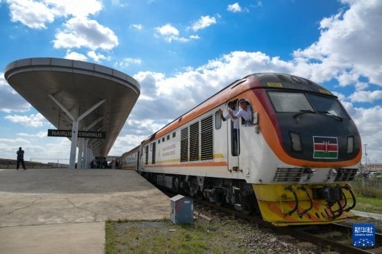 5月31日，在蒙內(nèi)鐵路內(nèi)羅畢站，機(jī)車(chē)駕駛員蔣立平（右）和博爾在即將開(kāi)往蒙巴薩的E2次列車(chē)上揮手致意。新華社記者 楊光 攝