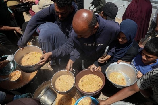 5月28日，人們在加沙城西部的沙提難民營領(lǐng)取救助食物。新華社發(fā)（里澤克·阿卜杜勒賈瓦德攝）
